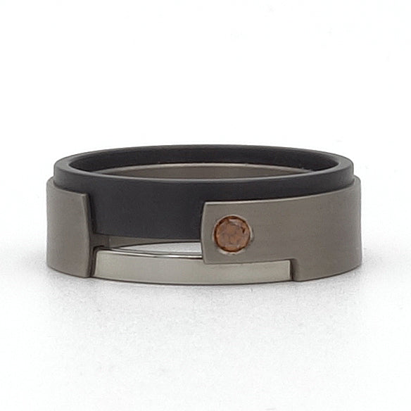 Enkele Aquila-ring in titanium, rode diamant en edelstaal. met strak, modern design.

