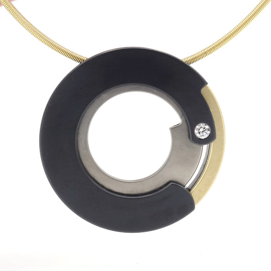 Ronde hanger van zwart zirkonium en roodgoud met een 0,05 ct diamant, modern design aan een metalen ketting.

