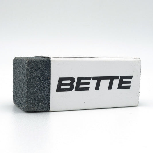 Bette sanitair gum voor het verwijderen van zwarte metaalstrepen op toilet en wastafel, close-up op witte achtergrond