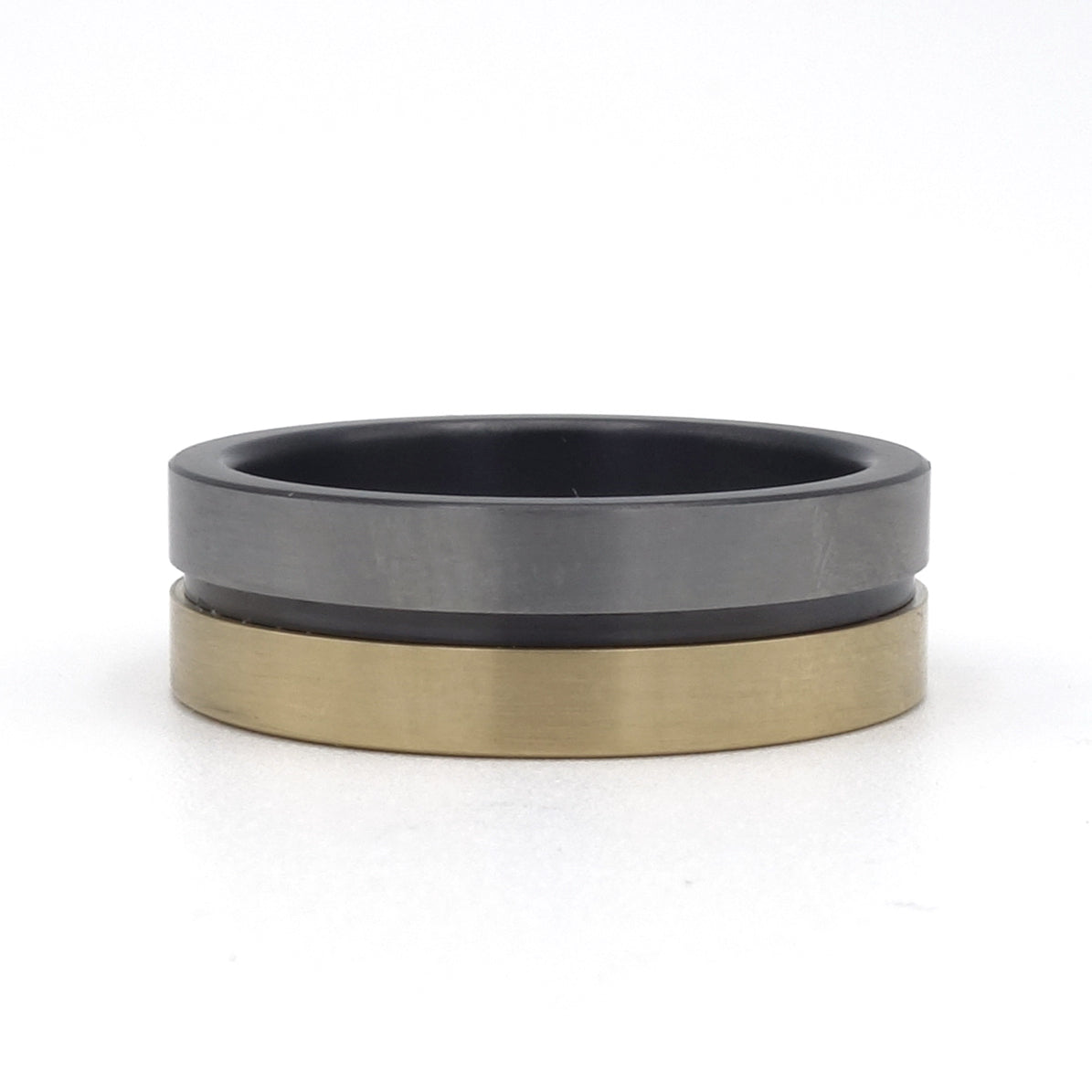 Lines-ring van zirkonium en geelgoud – strakke, moderne ring met subtiel lijnenspel en warm metaalaccent.


