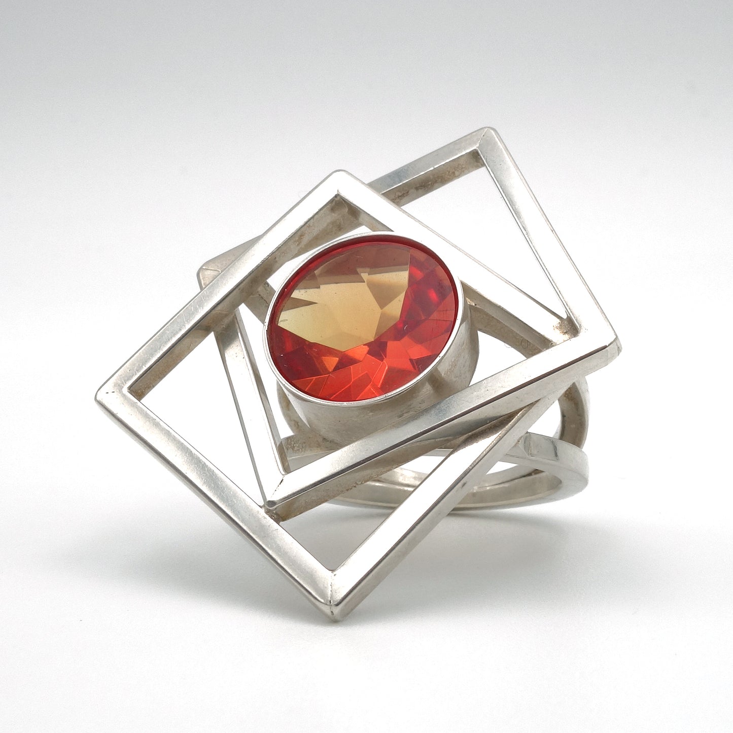 Bijzondere Zilveren, groot met twee vierkanten die door elkaar geweven zijn. met een grote edelsteen van 13 mm in oranje, synthetische Padparadja saffier