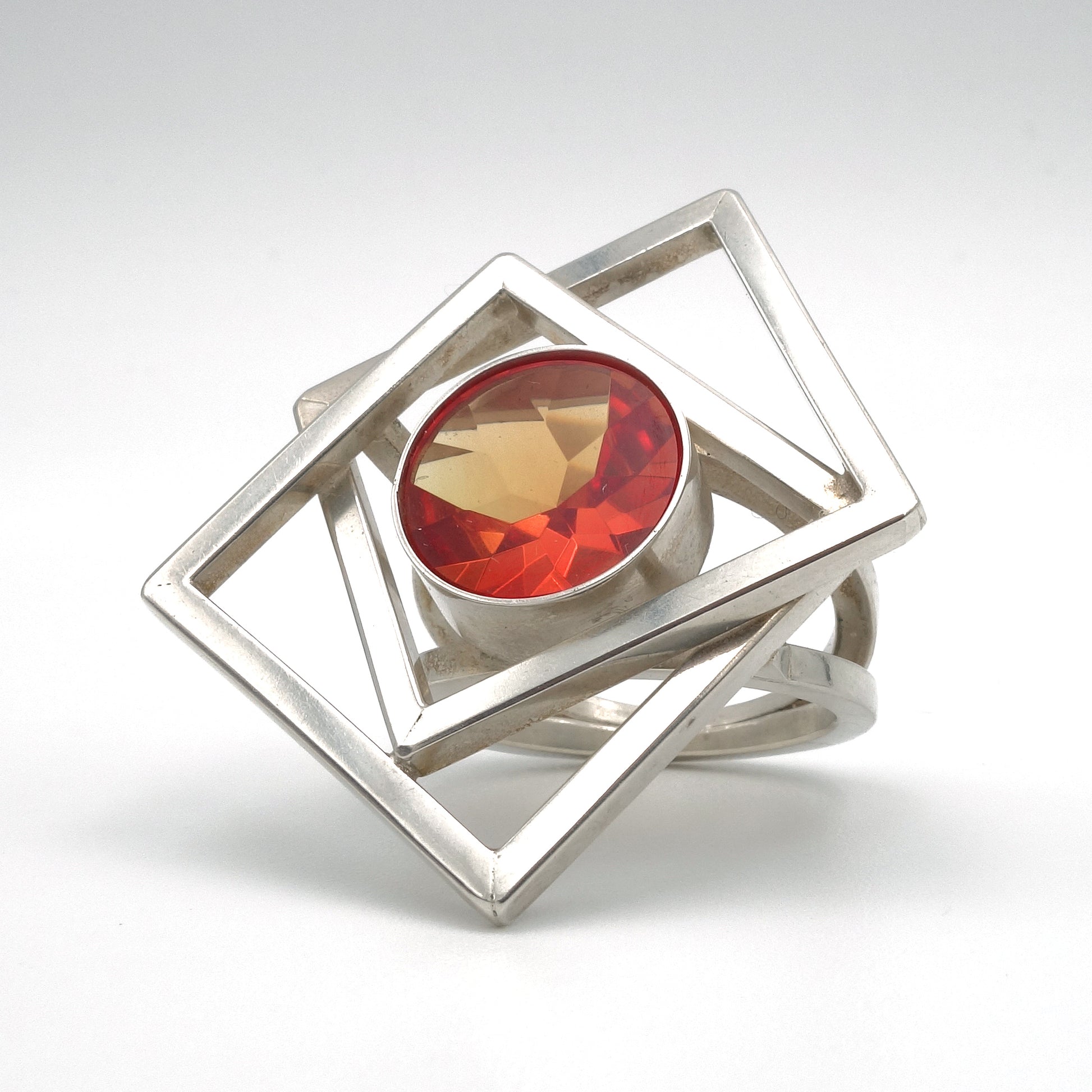 Bijzondere Zilveren, groot met twee vierkanten die door elkaar geweven zijn. met een grote edelsteen van 13 mm in oranje, synthetische Padparadja saffier