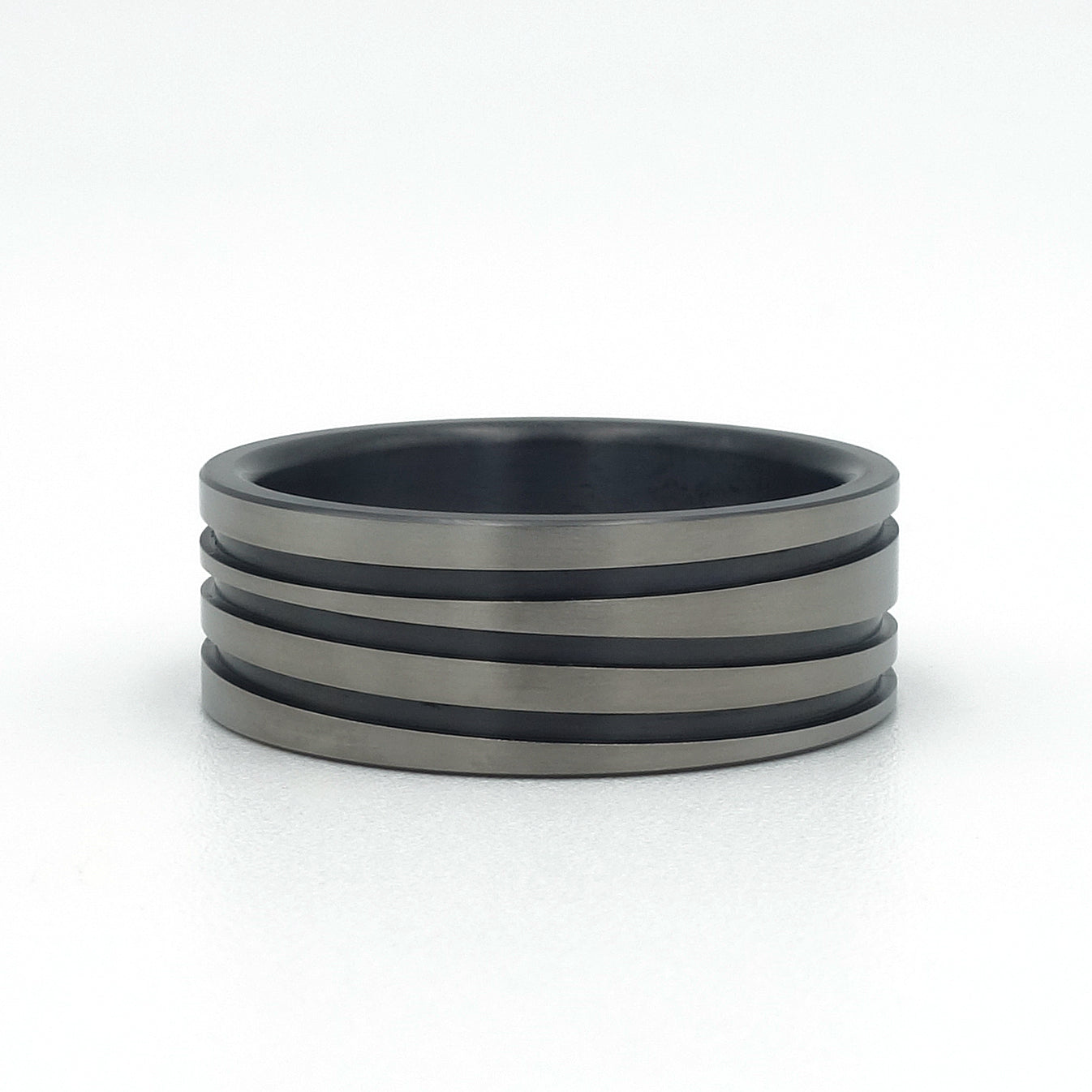 Zirkonium ring met drie zwarte lijnen, speels over de ring heen, rondom