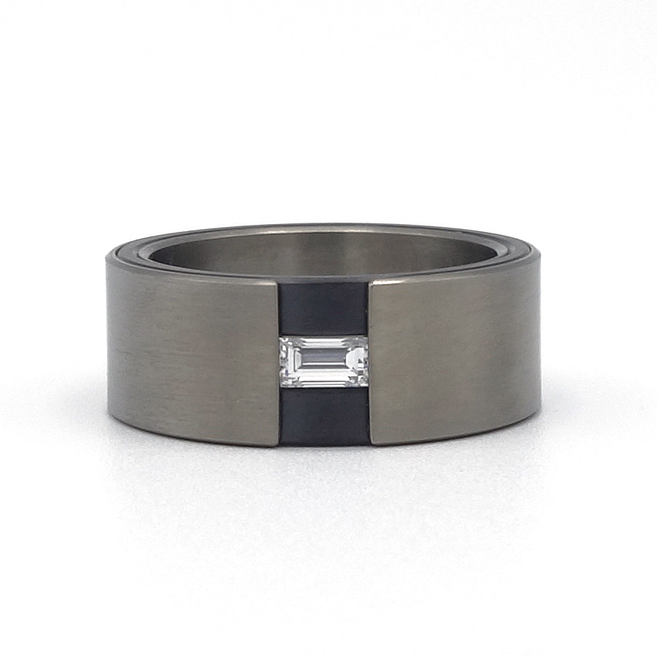 Titanium ring met zirkonium detail en baguette-geslepen diamant, moderne strakke vormgeving.