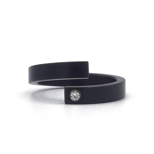 Volledig zwarte zirkoniumring met open vorm en kleine diamant van 0,02 ct – strak, subtiel en aanpasbaar in breedte.