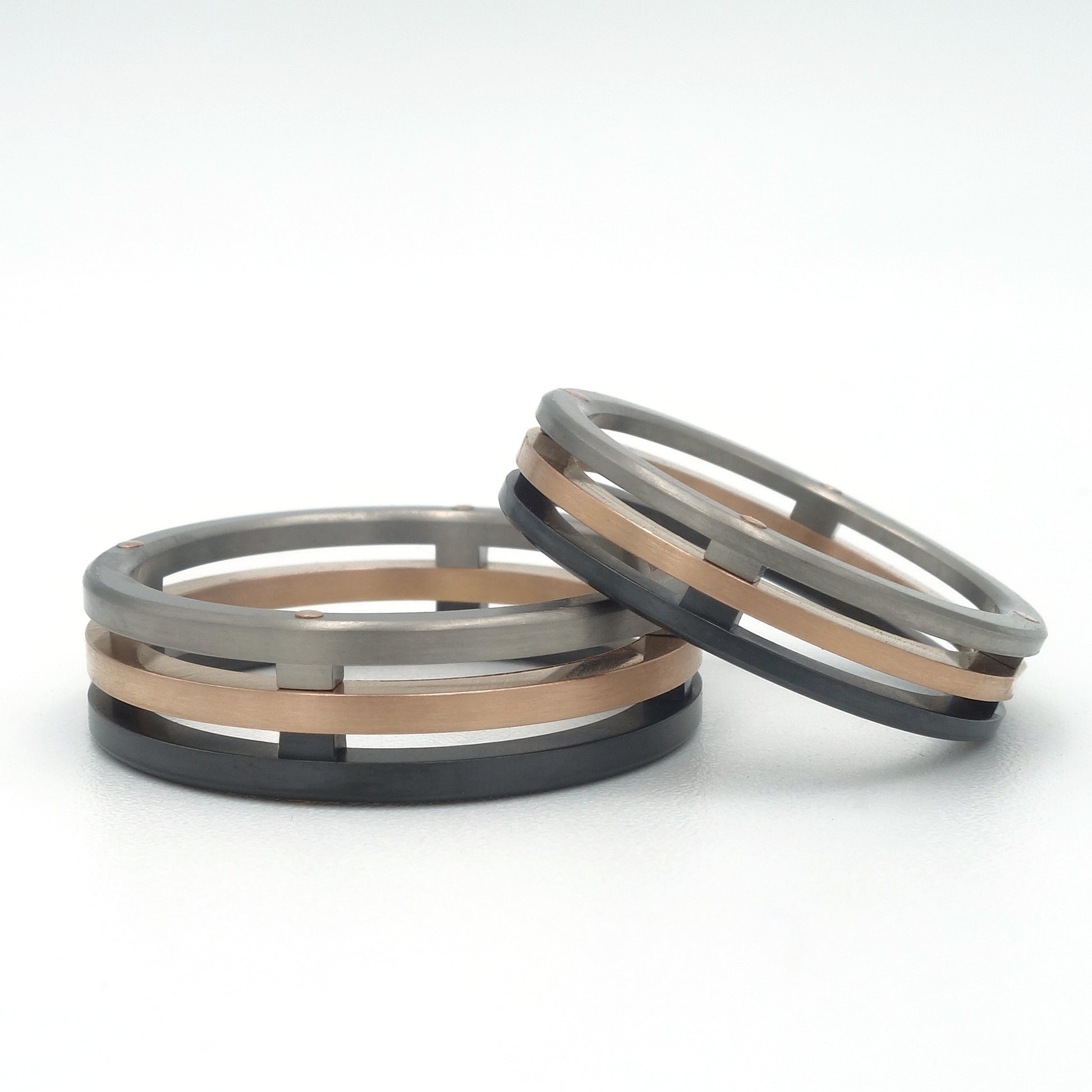 Florid ringenset van titanium met roodgouden baan en zwart zirkonium in een open, gelaagd ontwerp