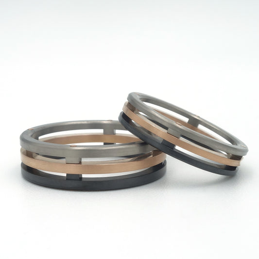 Florid ringenset van titanium met roodgouden baan en zwart zirkonium in een open, gelaagd ontwerp