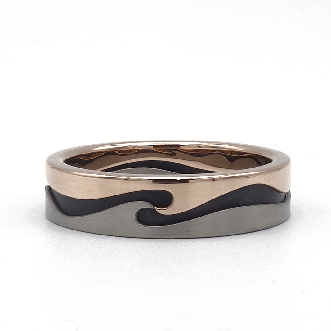 Supergolf ring van 18 karaat roodgoud, titanium en zirkonium met golvend patroon rondom.
