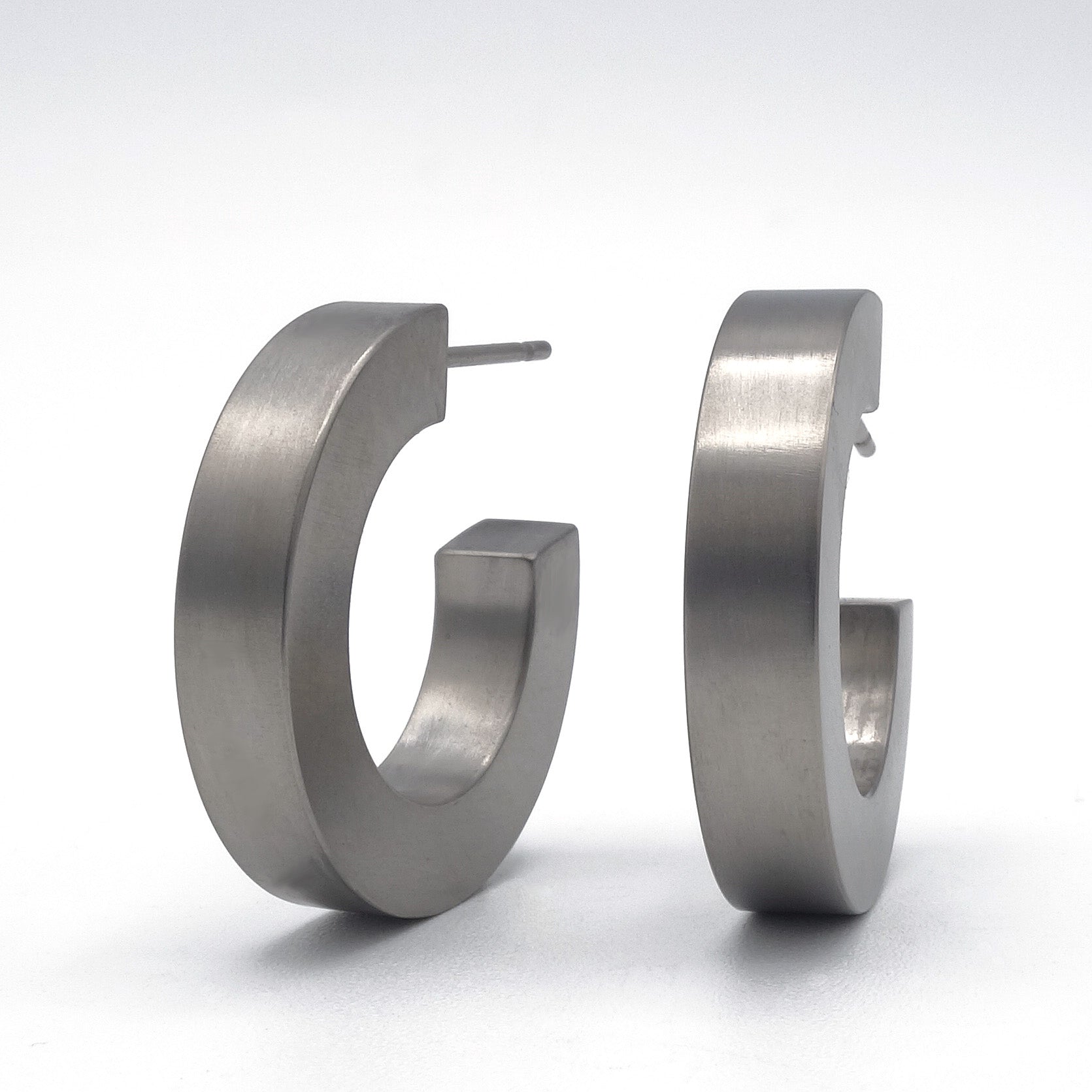 Grijze titanium creolen, 21 mm groot en 4 mm breed, met titanium stekers