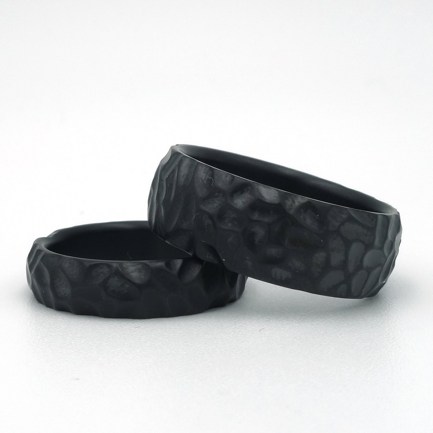 Zwarte zirkonium ringen met grove hamerslagstructuur in 5 mm en 8 mm breedte.