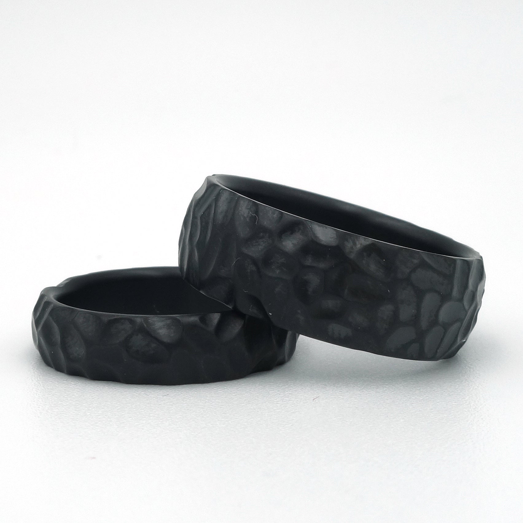 Zwarte zirkonium ringen met grove hamerslagstructuur in 5 mm en 8 mm breedte.