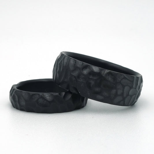 Zwarte zirkonium ringen met grove hamerslagstructuur in 5 mm en 8 mm breedte.
