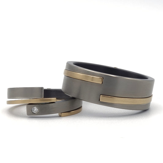Eva & Elica ringenset van zirkonium en geelgoud – speels en elegant ontwerp met diamantaccent in de damesring.

