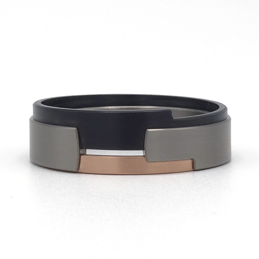 Aquila-ring van roodgoud, titanium en zirkonium – modern ontwerp met gelaagde materialen en warm roodgouden detail.

