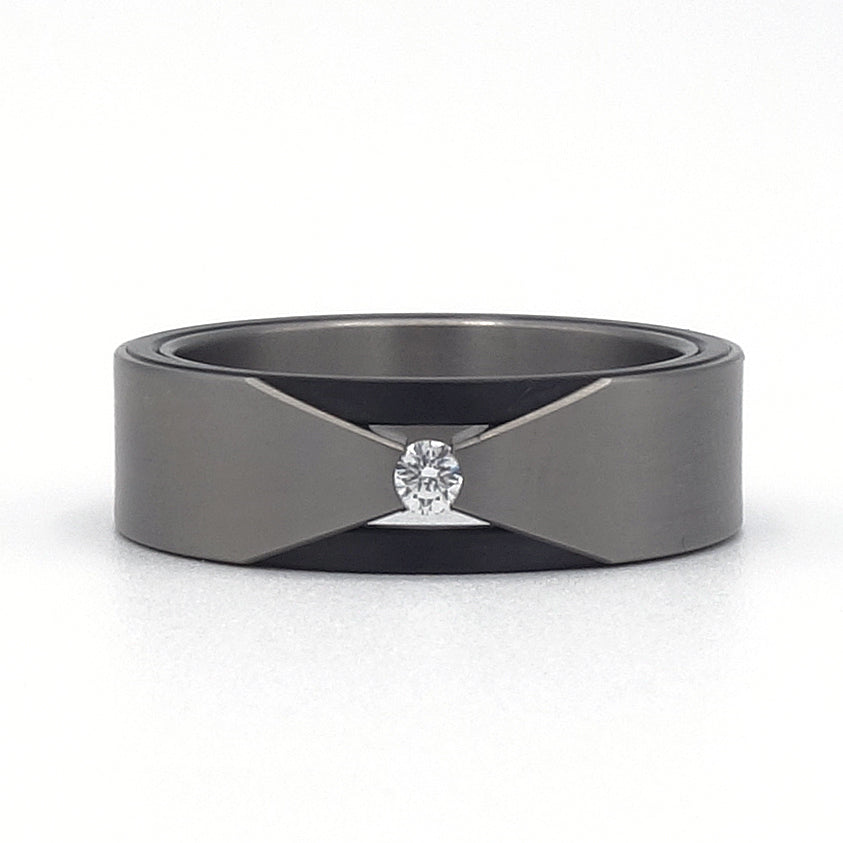 Titanium ring met V-vorm en briljant geslepen diamant gespannen tussen zirkoniumdelen.