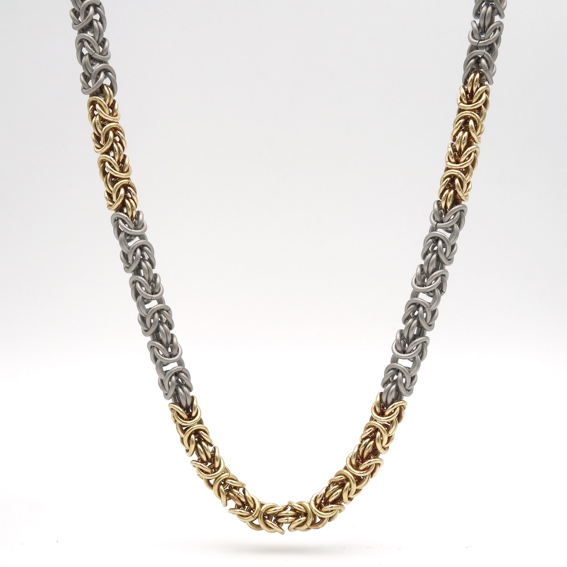 Handgemaakt collier met koningsketting schakels van titanium en 18 karaats geelgoud. 5.5 mm in dikte. Lengte 53 cm.