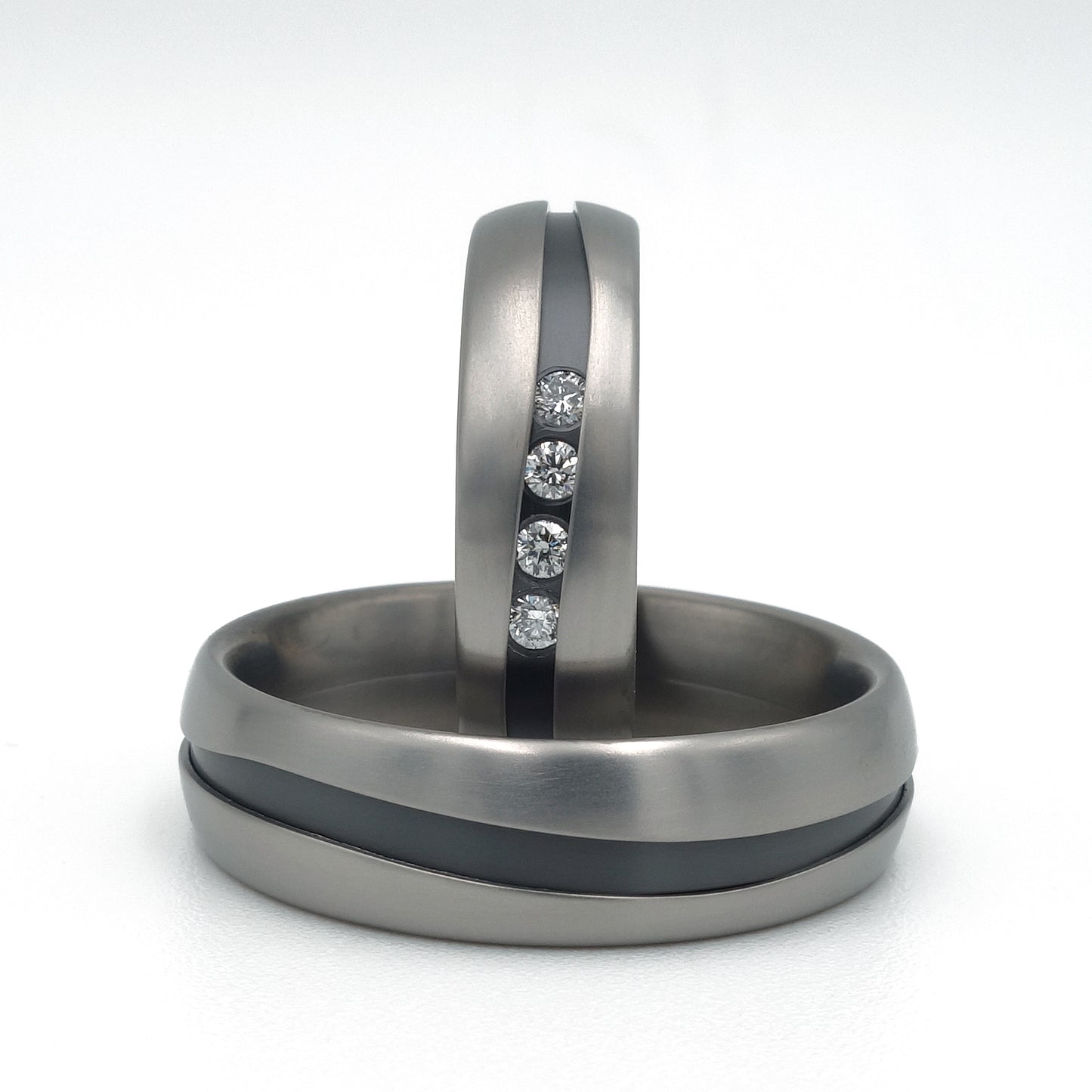 Fracta ringenset van titanium – klassiek ogende ringen met een vloeiende scheurvorm en vier diamanten in de damesring voor een verfijnde, moderne twist.

