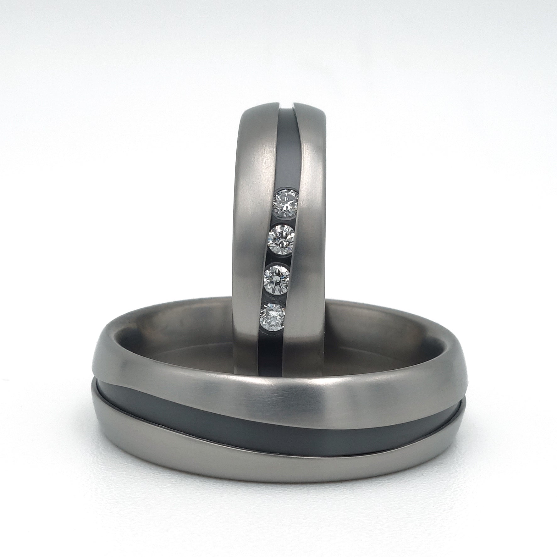 Fracta ringenset van titanium – klassiek ogende ringen met een vloeiende scheurvorm en vier diamanten in de damesring voor een verfijnde, moderne twist.

