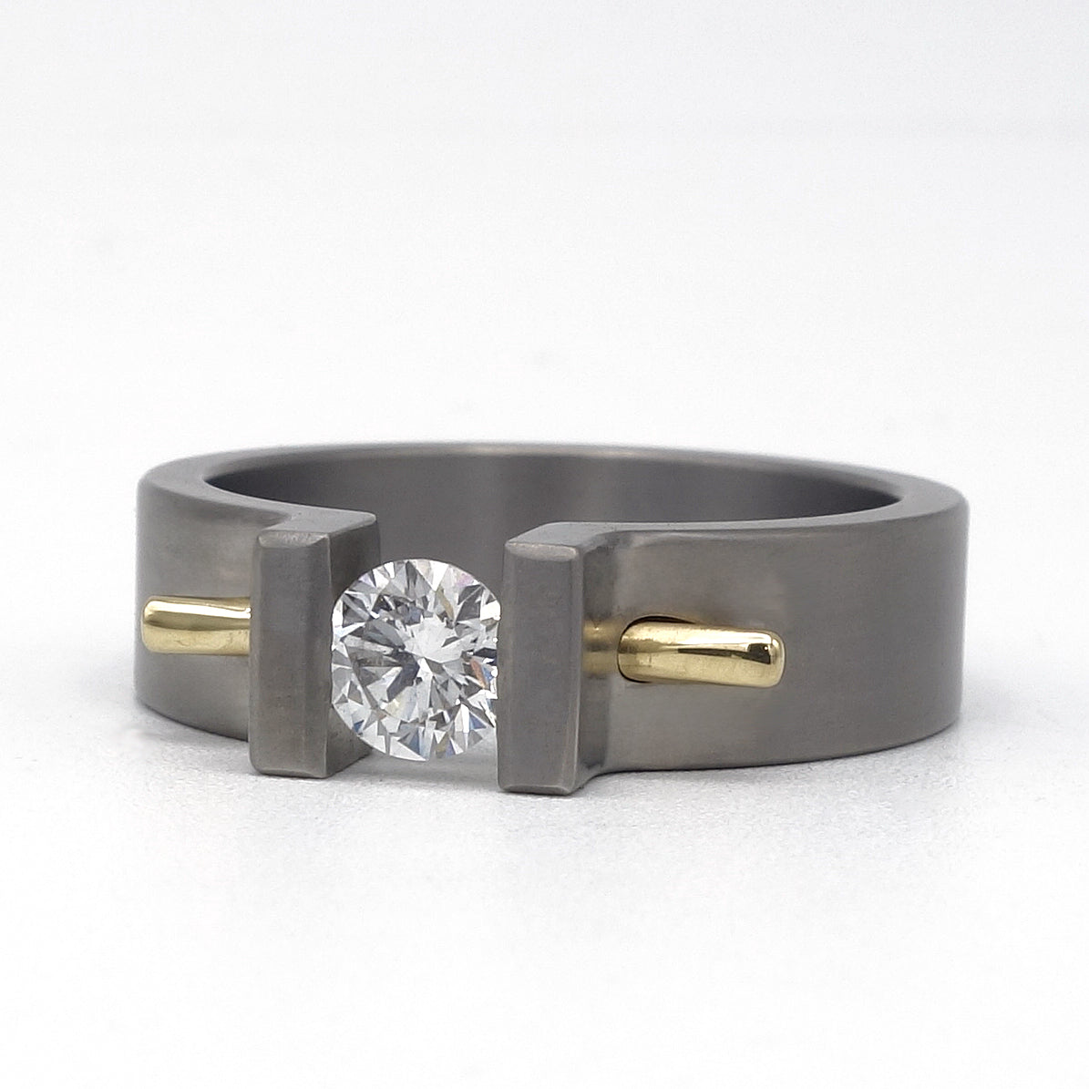 Moonrise ring van titanium met diamant en geelgouden pen als accent.