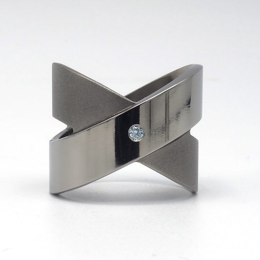 Titanium crossring in gesloten X-vorm met blauwe diamant Ice 0,05ct glad omgezet, Lea II van Metal Art Sieraden.