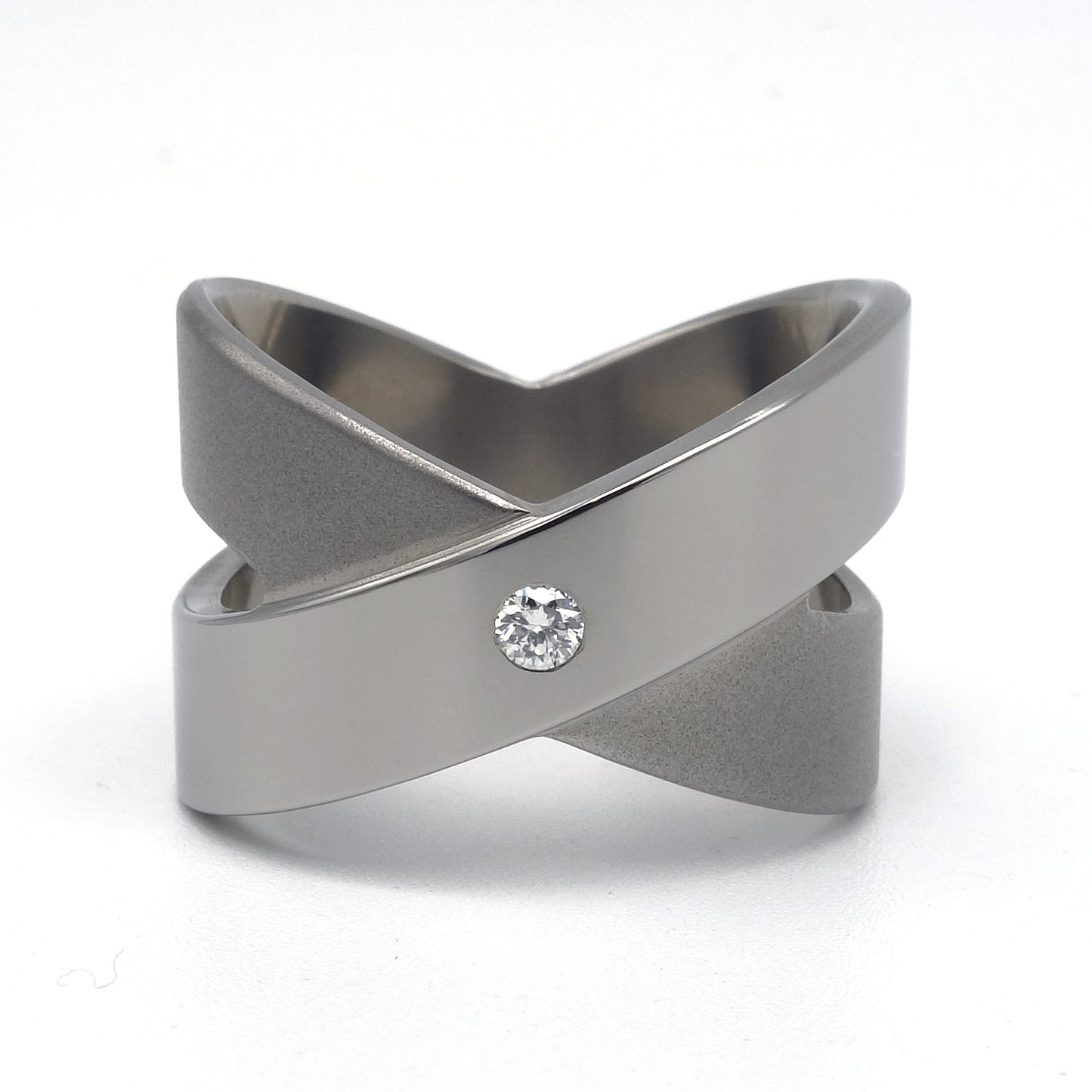 Brede titanium ring in open kruisvorm met gepolijste diagonale band en ingezette witte briljant 0,05ct, Lea II Smal van Metal Art Sieraden.