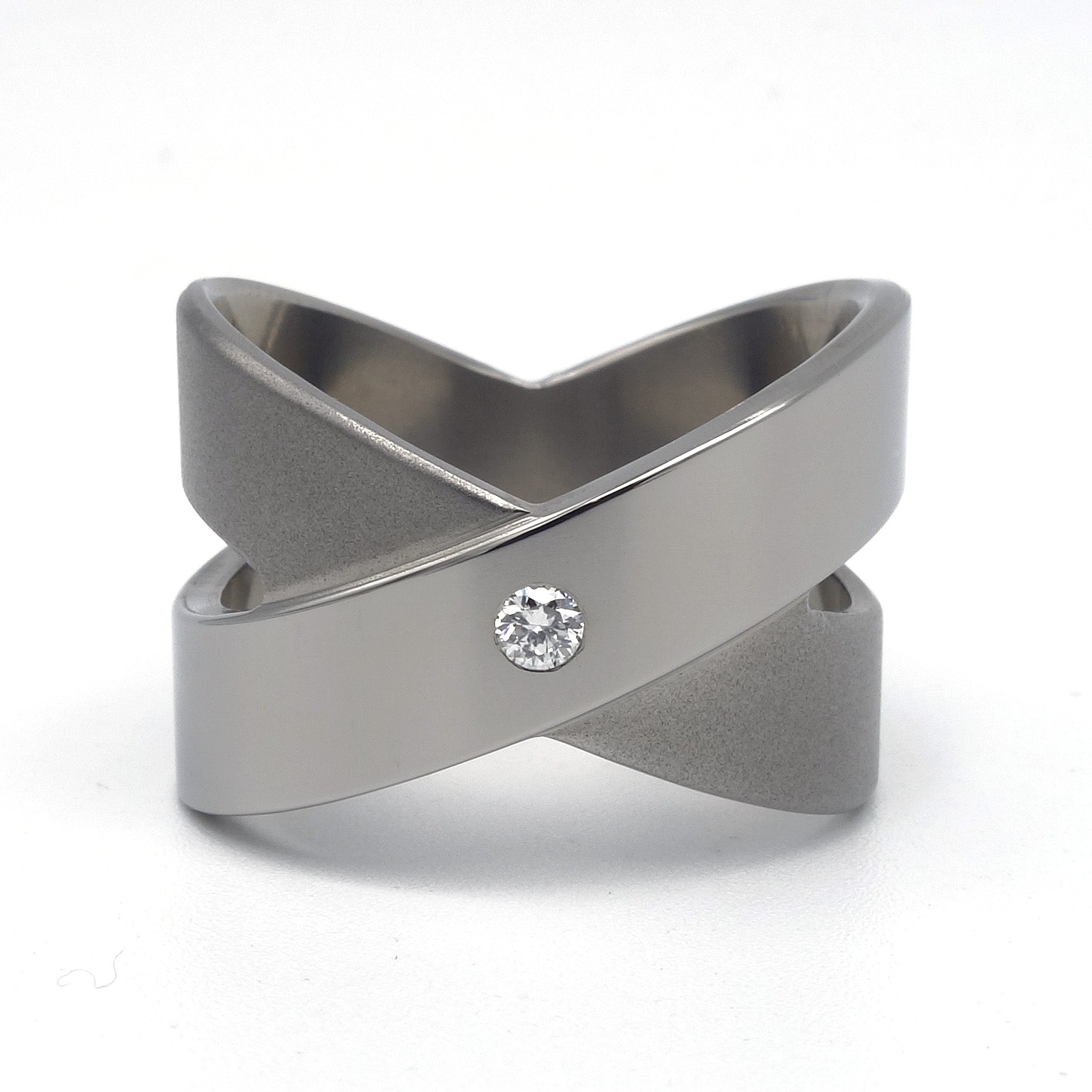 Brede titanium ring in open kruisvorm met gepolijste diagonale band en ingezette witte briljant 0,05ct, Lea II Smal van Metal Art Sieraden.