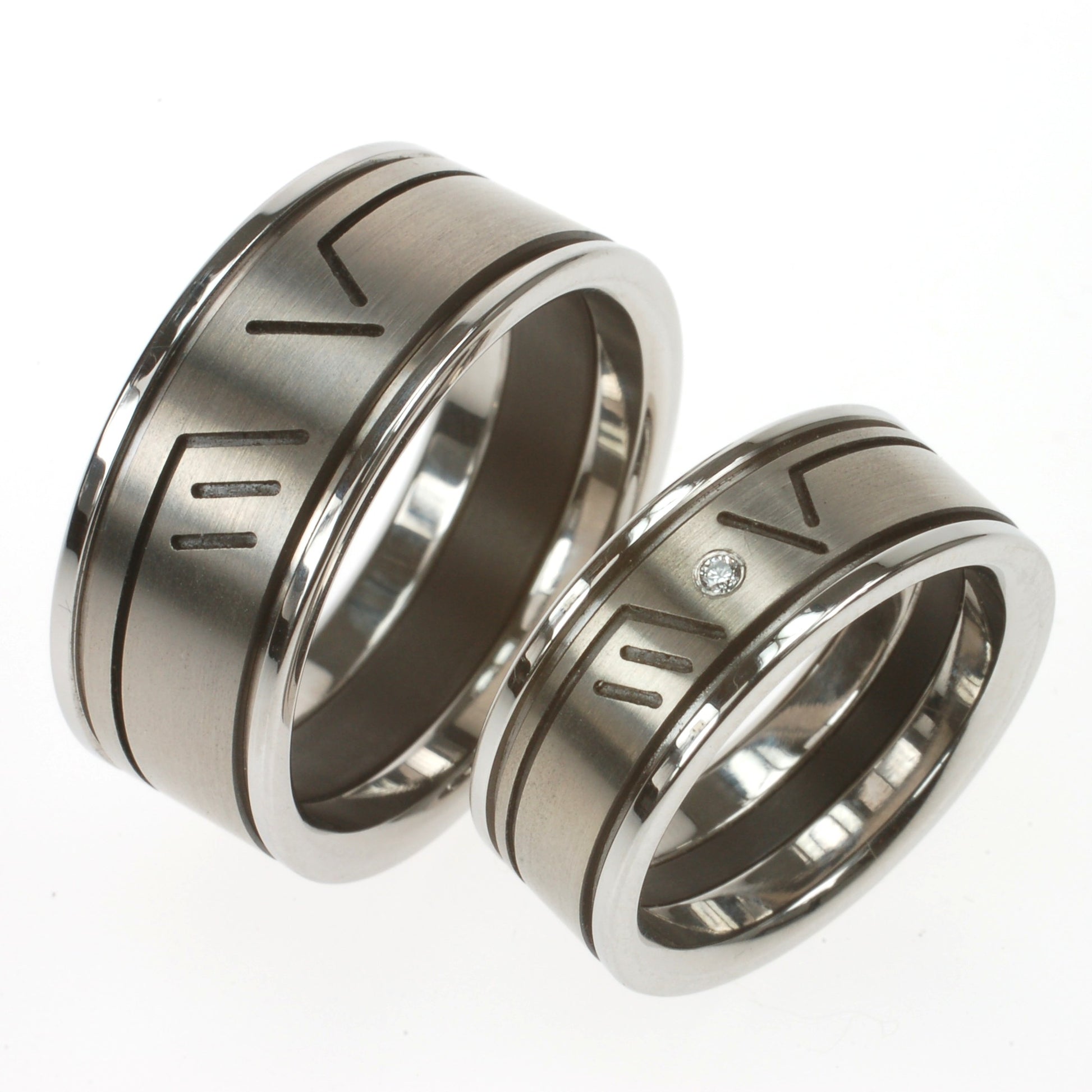 Modulaire trouwringen van titanium, edelstaal en zwart zirkonium met ingefreesde initialen M V en diamant