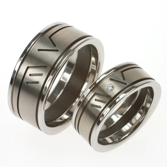 Modulaire trouwringen van titanium, edelstaal en zwart zirkonium met ingefreesde initialen M V en diamant