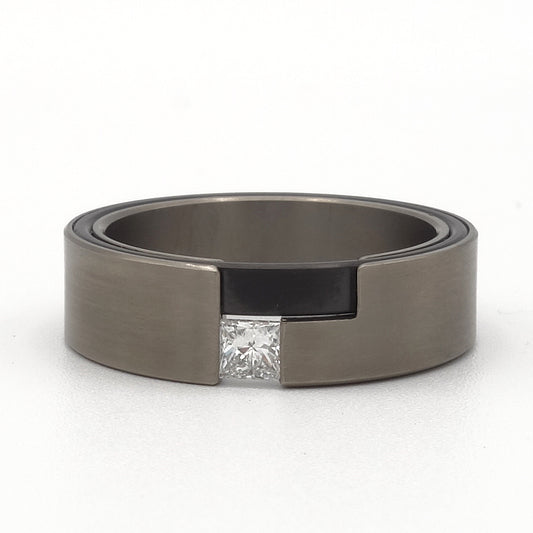 Leona-ring van titanium en zwart zirkonium met prinsesgeslepen diamant – moderne damesring met grafisch contrast.

