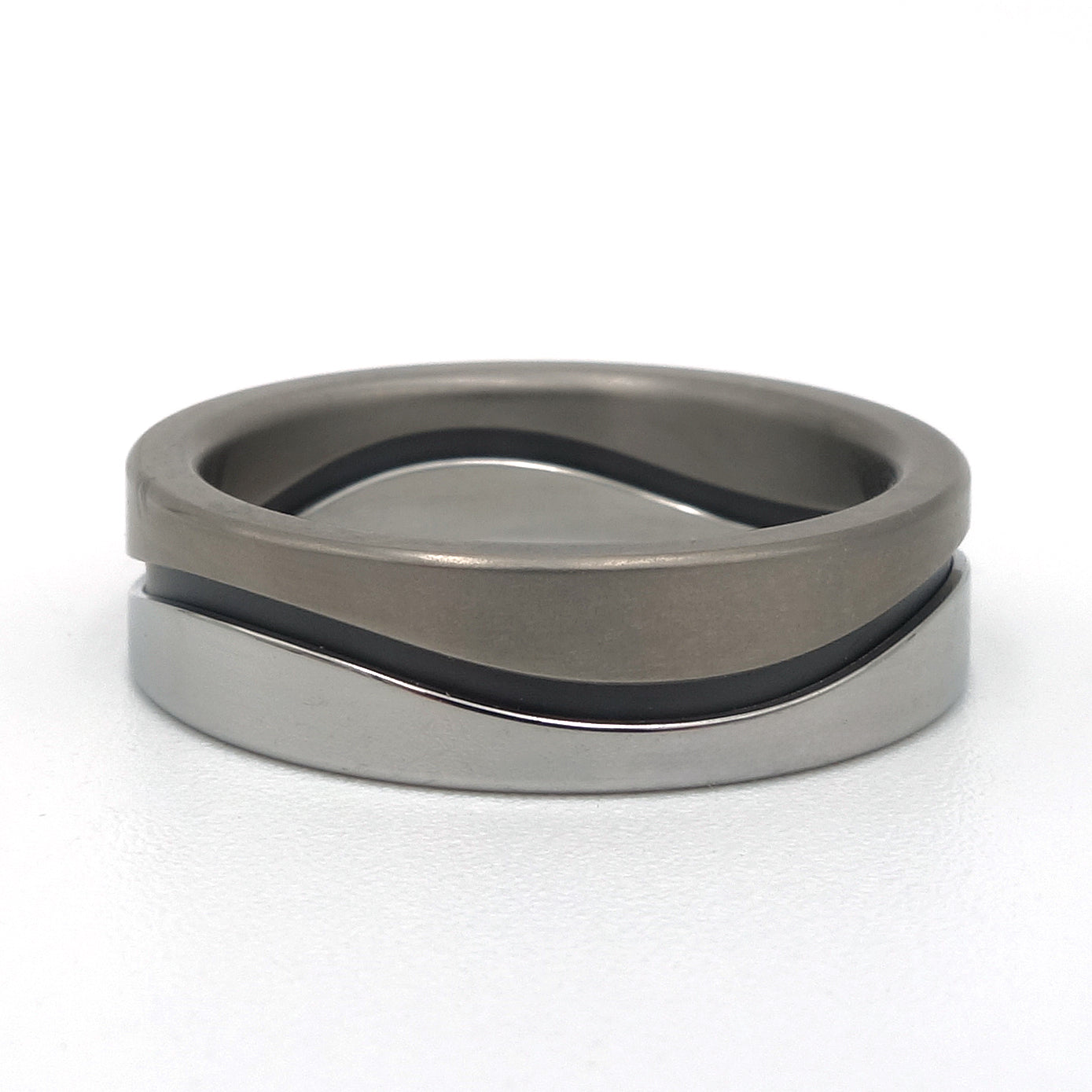 Ring met golvende lijn in mat titanium, zwart zirkonium en gepolijst edelstaal, 7 mm breed