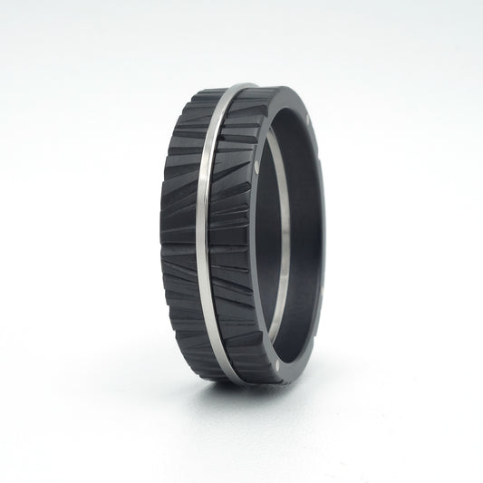 Moderne Pepe ring van zwart zirkonium en edelstaal met gefreesd, radiaal patroon