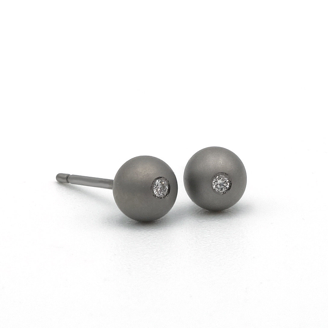 parelvormige oorbel van titanium met kleine diamant in het midden 0.01 ct. Maat oorbel is 4.75 mm