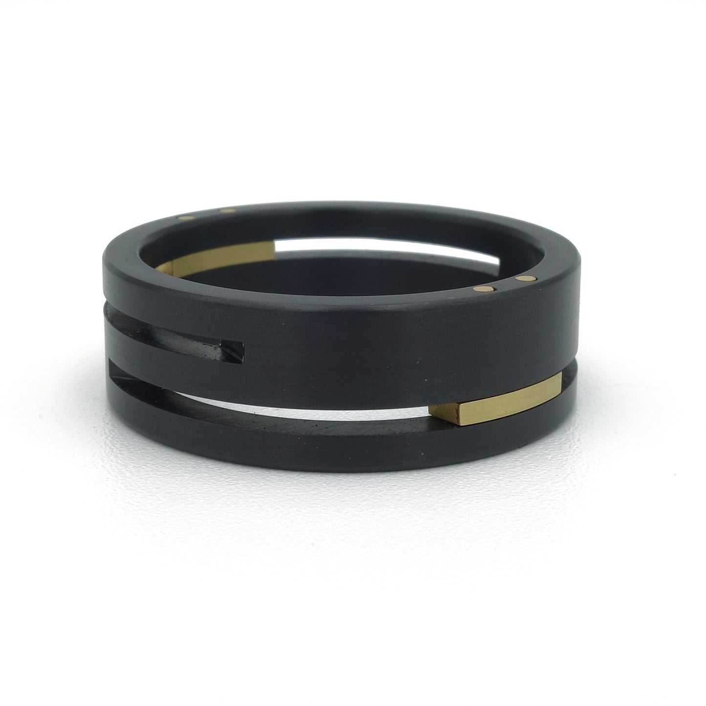 Split-Level ringenset van zirkonium en geelgoud – strak, modern ontwerp met verdiept lijnenspel en opvallend kleurcontrast.

