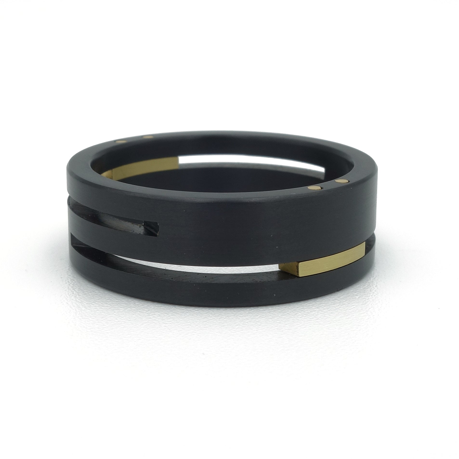 Split-Level ringenset van zirkonium en geelgoud – strak, modern ontwerp met verdiept lijnenspel en opvallend kleurcontrast.

