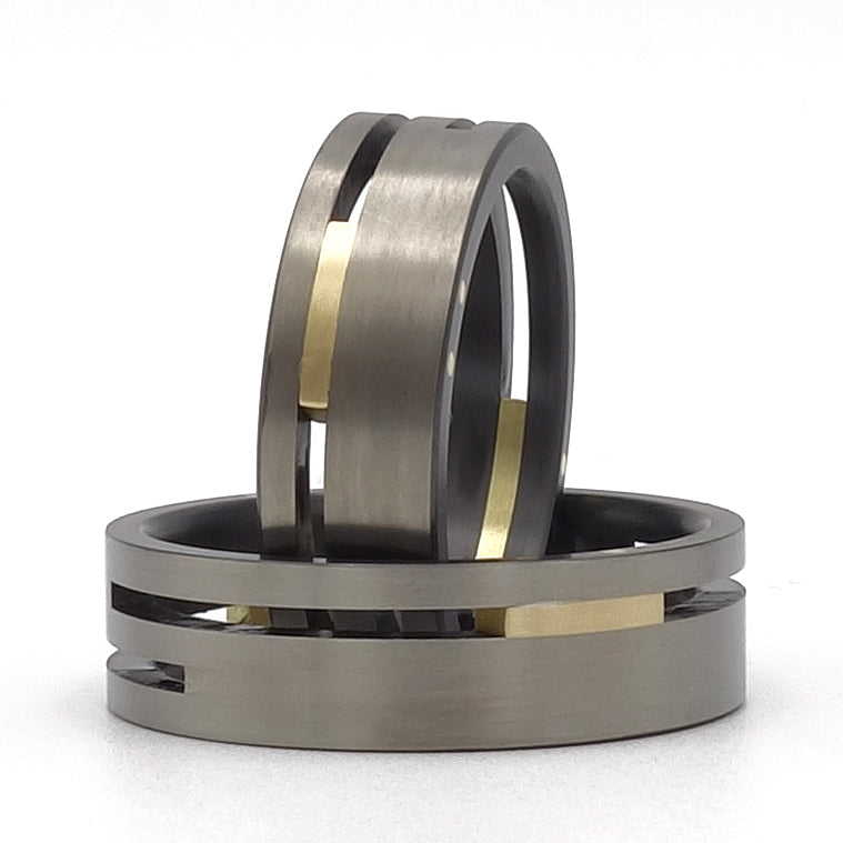 Set Split-Level trouwringen van zirkonium en geelgoud – eigentijds duo met verdiept midden en sterk kleurcontrast.

