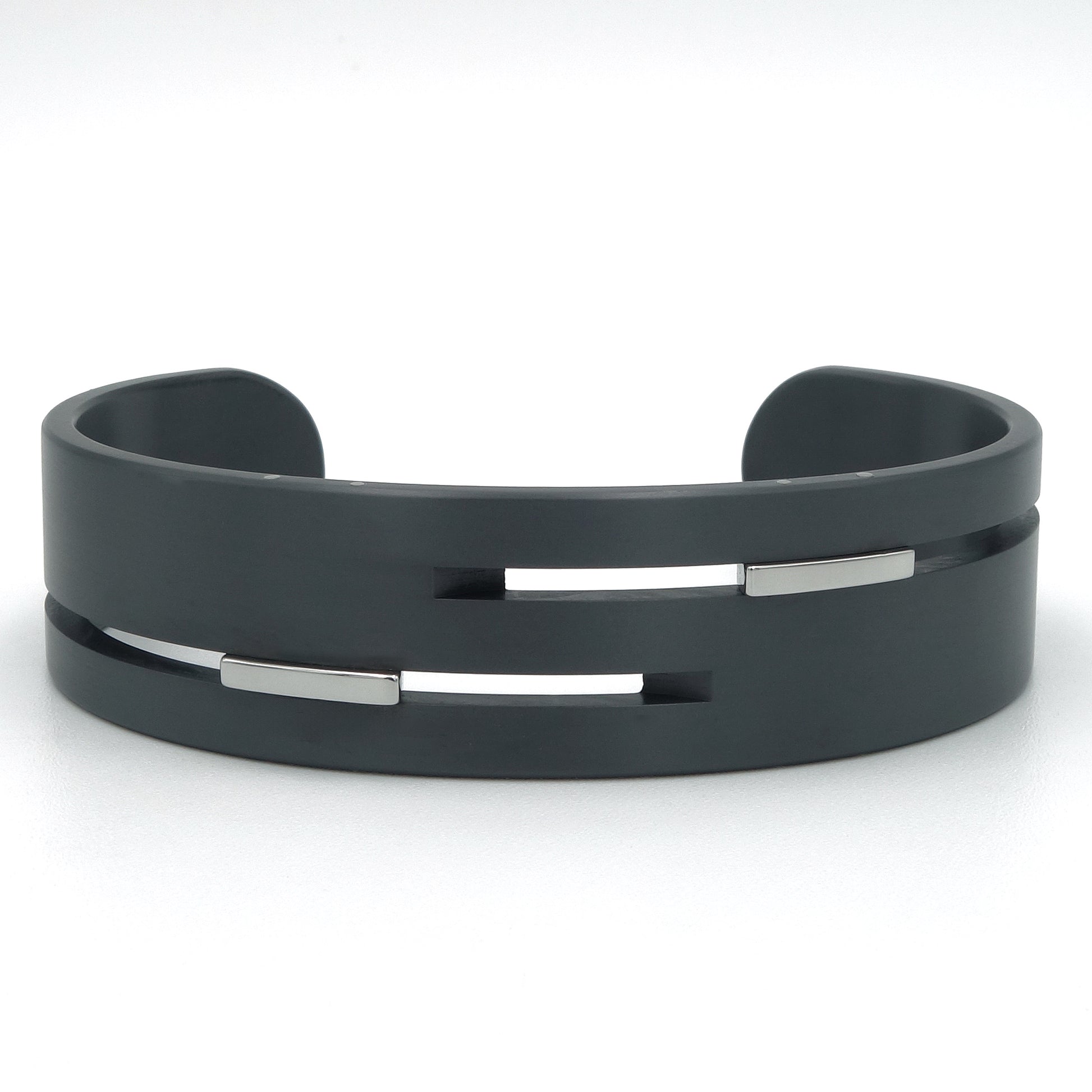 Brede open bangle van zwart zirkonium met gepolijste edelstalen inserts in horizontale gleuven, 18mm breed, mat afgewerkt.