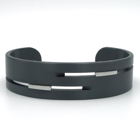 Brede open bangle van zwart zirkonium met gepolijste edelstalen inserts in horizontale gleuven, 18mm breed, mat afgewerkt.