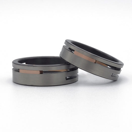 Split-Level ringenset van zirkonium en roodgoud – moderne trouwringen met verdiept midden en krachtig kleurcontrast.

