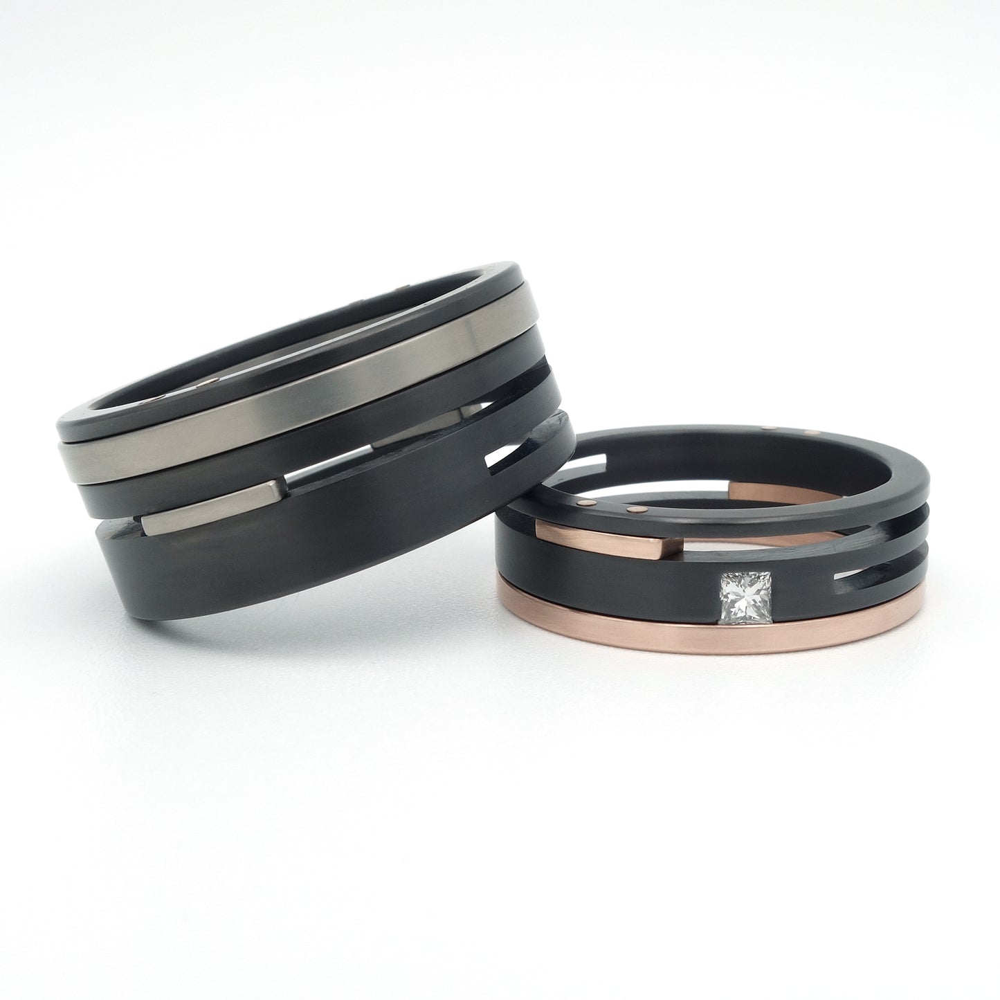 Stoere trouwringen in zirkonium, titanium en roodgoud — Split Level Special met princess diamant van Metal Art Sieraden.
