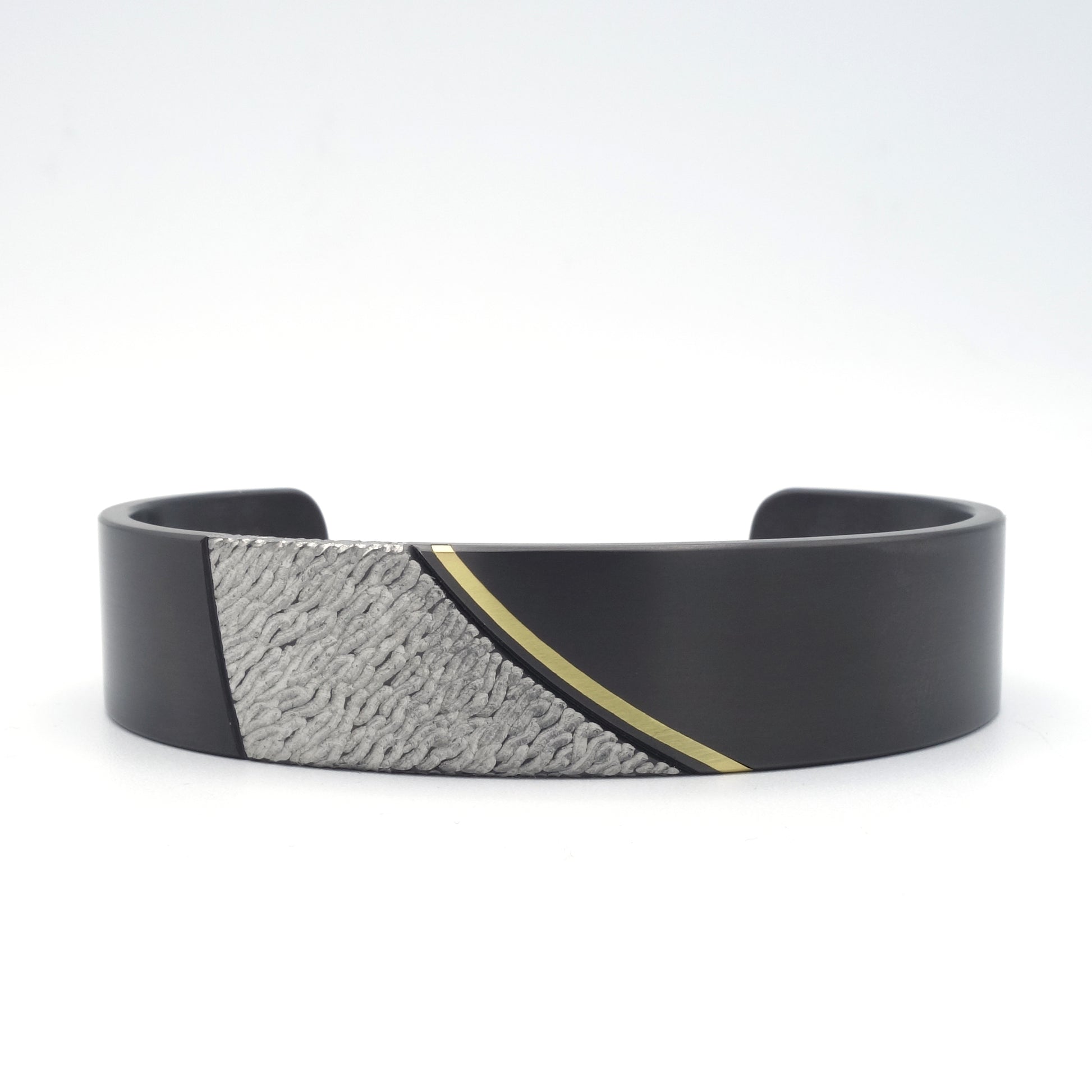 Strand armband van zwart zirkonium met 18kr geelgouden inleg en strandstructuur, variant zonder diamanten.