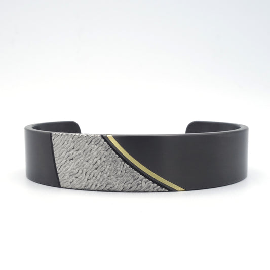 Strand armband van zwart zirkonium met 18kr geelgouden inleg en strandstructuur, variant zonder diamanten.