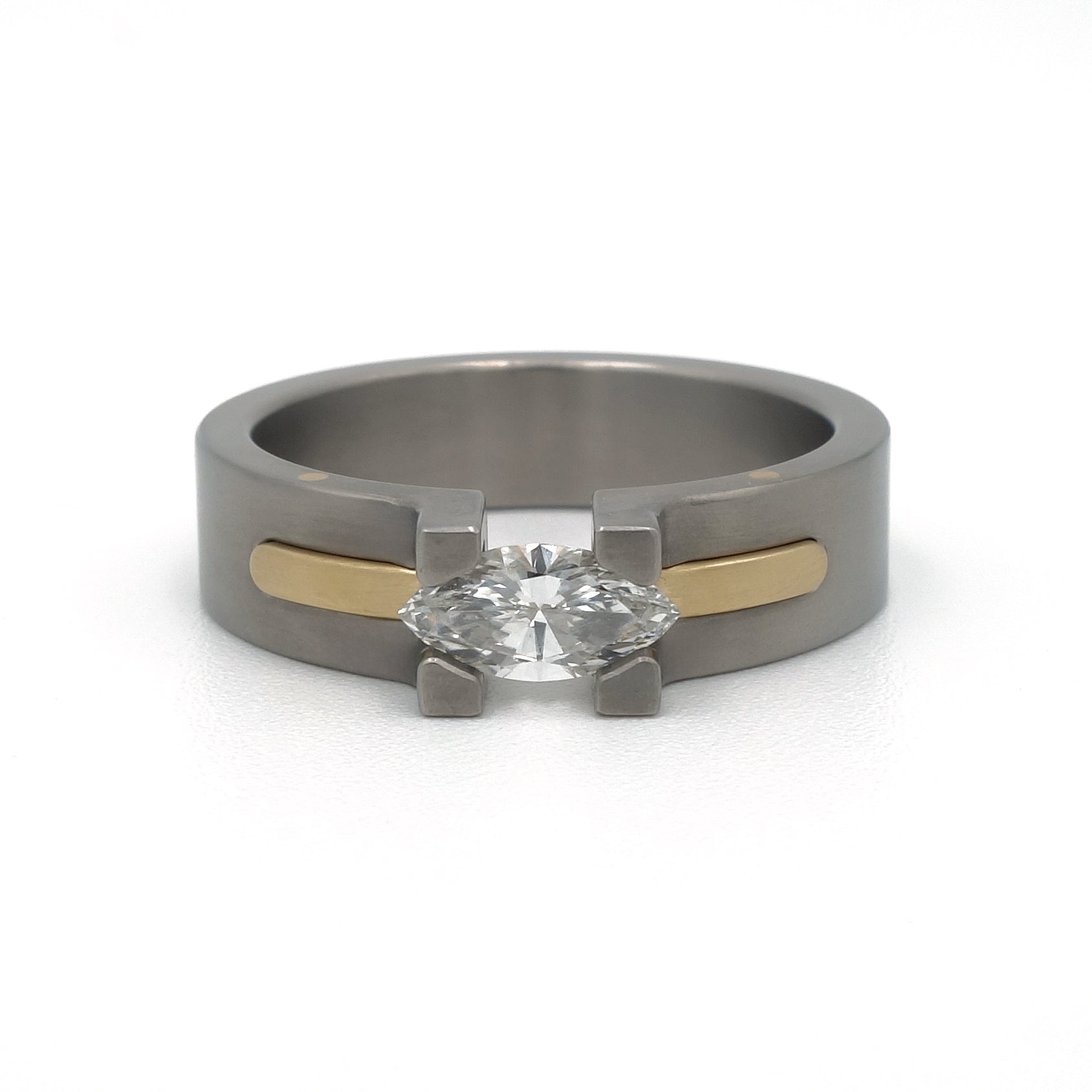 Damesring Sunrise van titanium en 18-karaat geelgoud met marquise diamant in optische spanzetting.