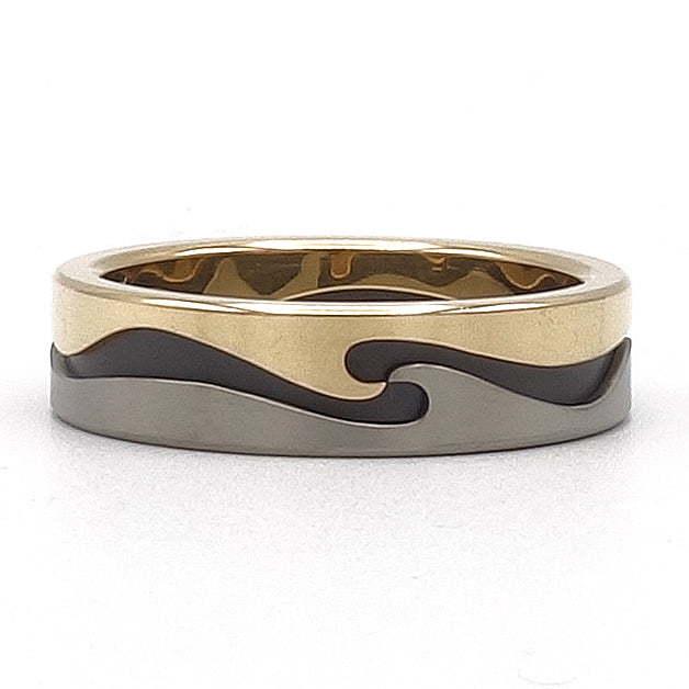 Supergolf ring van 18 karaat geelgoud, titanium en zirkonium met golvend patroon rondom.