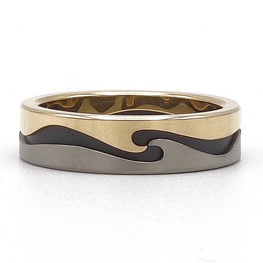 Supergolf ring van 18 karaat geelgoud, titanium en zirkonium met golvend patroon rondom.