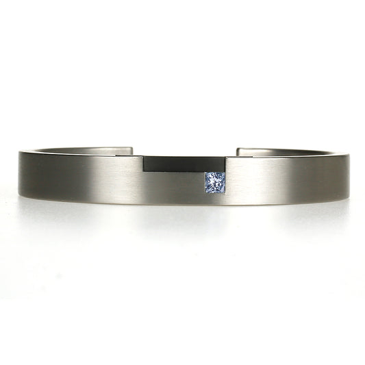 Strakke titanium armband met blauwe prinsesgeslepen diamant en zwart zirkonium detail, moderne maatwerkarmband.