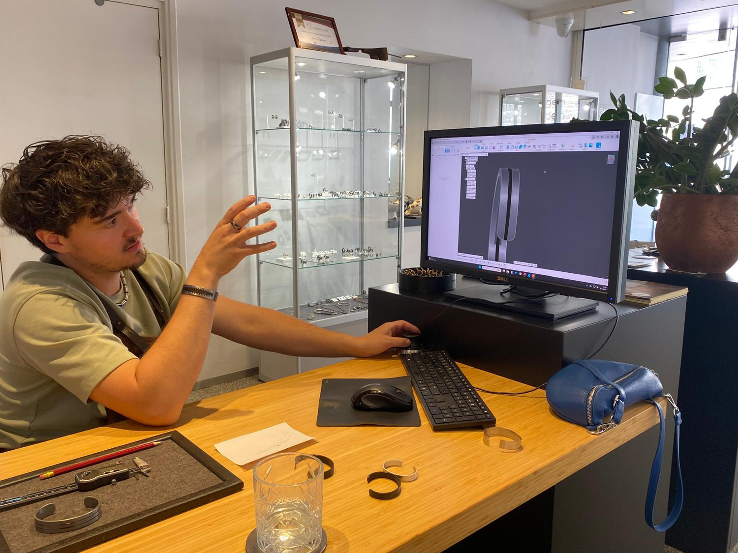 Wouter ontwerpt samen met een klant een armband op de computer in de Metal Art-stijl tijdens een persoonlijk ontwerpgesprek.