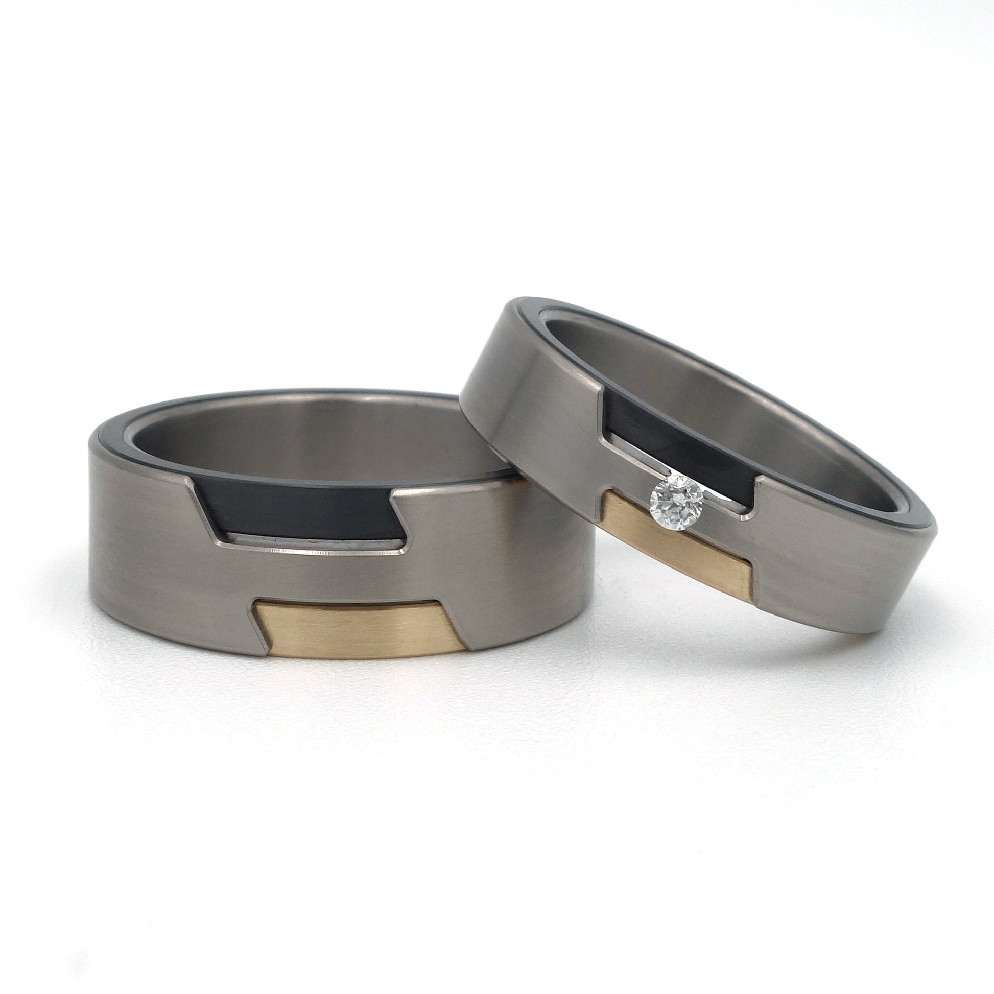 Trouwring Zem Special in titanium met zwart zirkonium en geelgoud zij-insteek, gezet met een briljant geslepen diamant van 0.05ct.