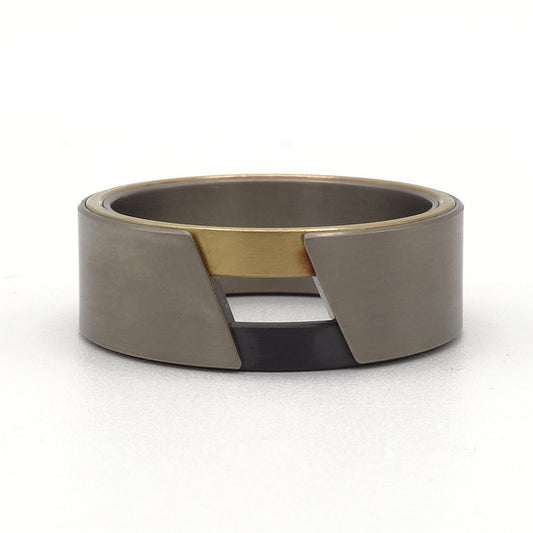 Zem-ring van titanium, zirkonium en 18k geelgoud – strak vormgegeven ring met opvallend kleurcontrast en moderne lagen.

