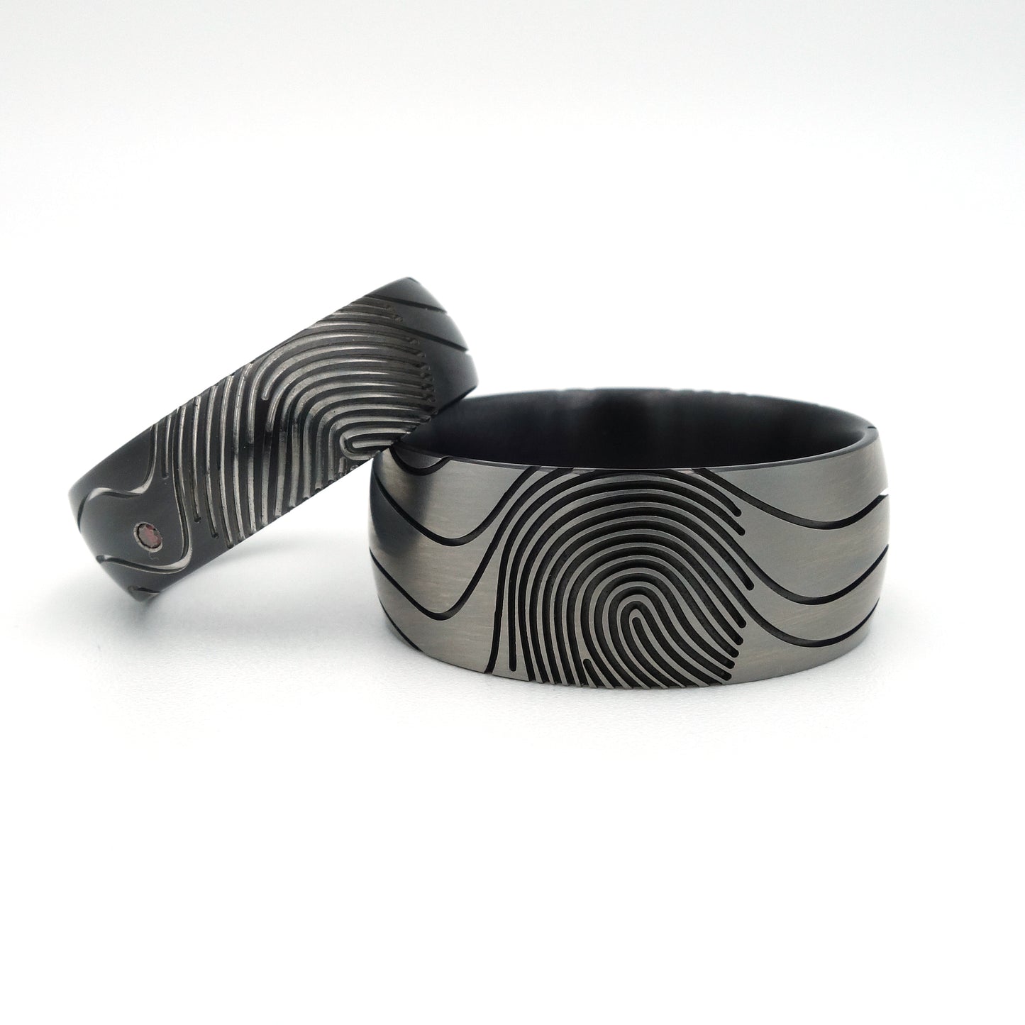 Vingerafdruk Contra trouwringen van zirkonium met artistieke vingerafdrukken en diamant van 0.015 ct.