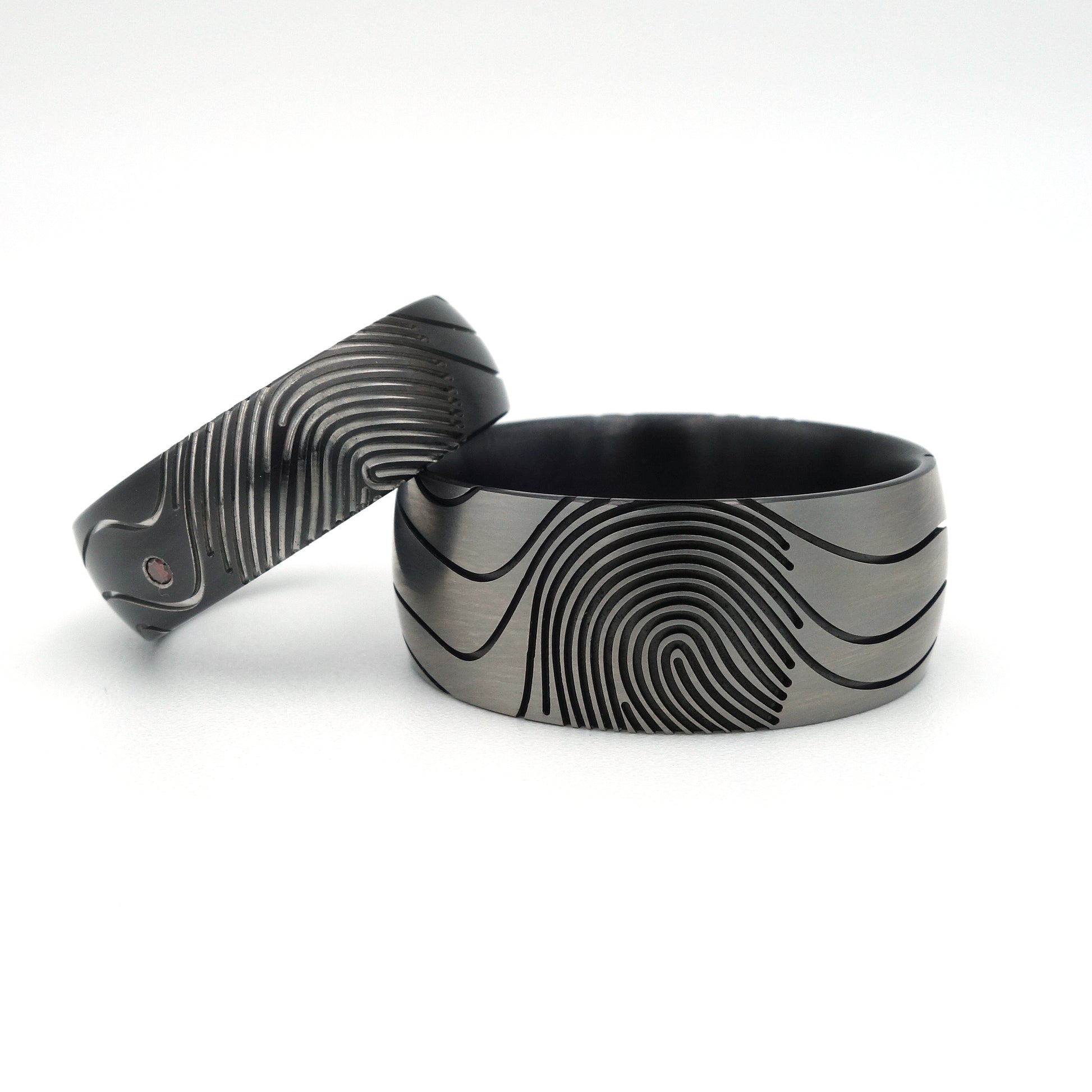 Vingerafdruk Contra trouwringen van zirkonium met artistieke vingerafdrukken en diamant van 0.015 ct.